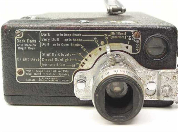 Top of Cine Kodak Model K showing engraved exposure guide chart with lighting conditions and aperture settings, lens assembly, and footage counter dial