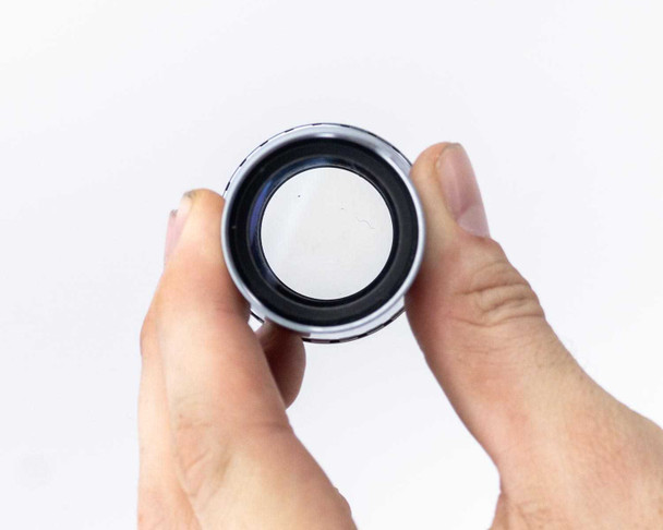 Photo-Sonics KB-19A lens – front element view showing white coating residue or contamination on glass