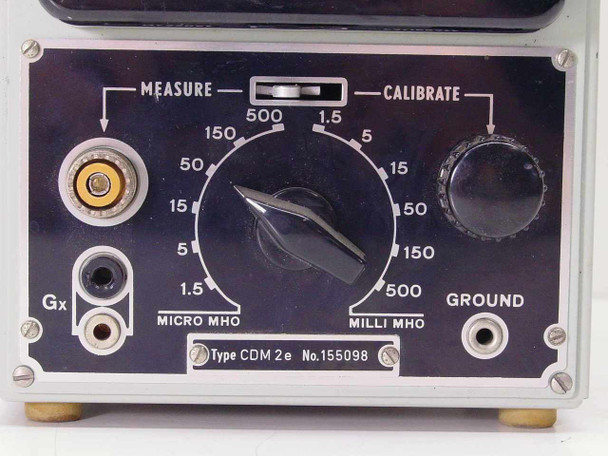 Close-up of Radiometer Copenhagen CDM 2e lower front panel showing Measure/Calibrate rotary range selector (1.5–500 Micro MHO and Milli MHO), Gx input connector, Ground terminal, and type plate reading CDM 2e No. 155098