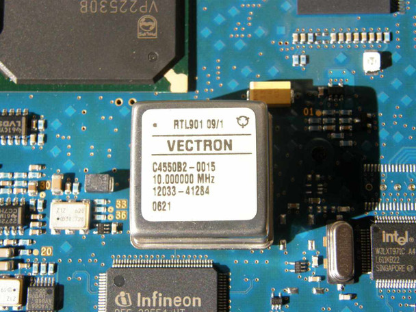 Ericsson CBU1 PCB close-up of Vectron oscillator module C4550B2-0015 (10.000000 MHz) and adjacent Infineon and Intel ICs