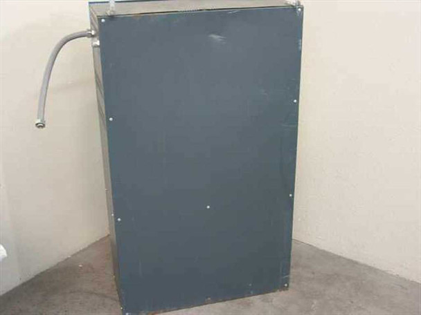 Industrial UPS cabinet rear view showing gray metal enclosure and conduit exit at top