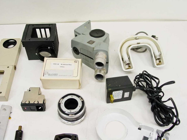 Close-up grouping showing black filter cube, gray optical head with dual ports, white ring light illuminators with cables, small power supply, and a labeled filter box