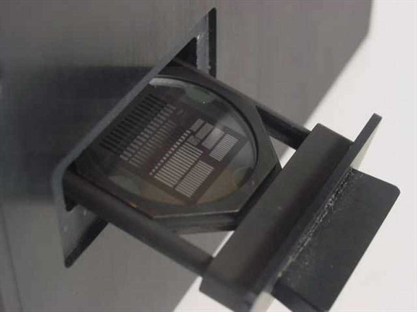 Interior reticle slide holder showing resolution test chart or grid reticle mounted in black anodized slide frame