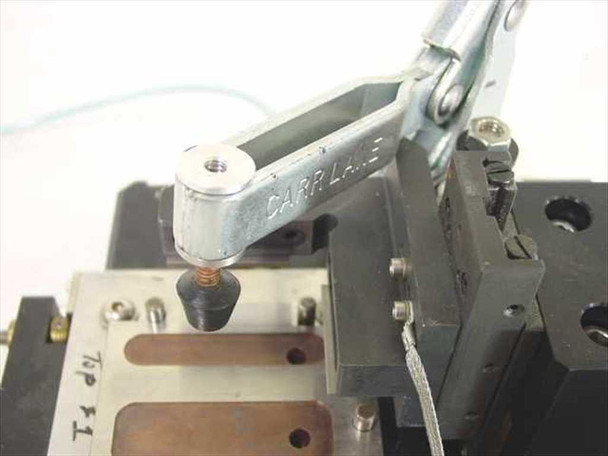 Close-up of Carr Lane toggle clamp arm stamped with brand name, hold-down plunger tip, and machined aluminum PCB nest with label reading '76P T1'