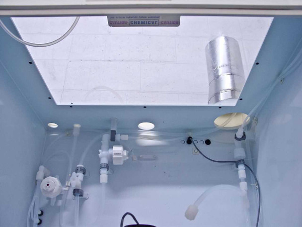 Interior top view of chemical daytank cabinet showing CHEMICVF warning label, exhaust diffuser, tubing manifold, and plumbing components