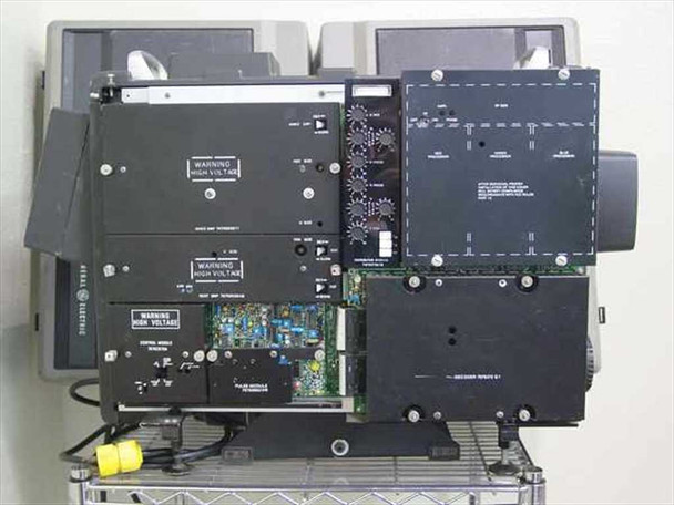 GE Talaria PJ5055C1 — rear panel open view showing multiple internal modules with High Voltage warning labels; circuit boards and wiring harnesses visible; unit on wire shelf