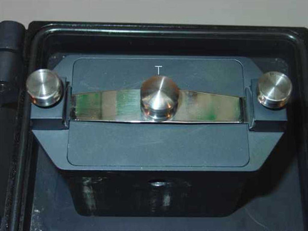 McPherson GCA film head assembly interior close-up showing film transport channel with film strip loaded, polished film guide posts, and aperture marked T