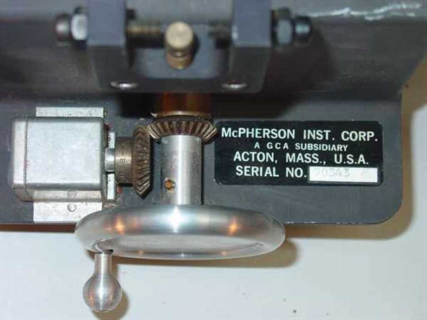 McPherson Instrument Corp. nameplate close-up showing manufacturer name, GCA subsidiary designation, Acton Massachusetts USA, serial number, and gear/drive mechanism detail