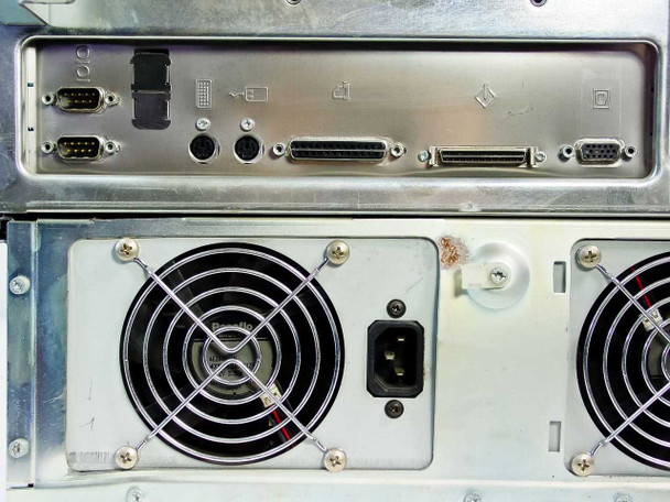 Rear I/O port detail — dual DB-9 serial ports, parallel port, SCSI connector, and PS/2-style connectors; surface spot of rust visible near fan housing