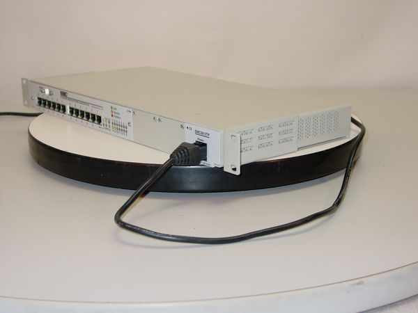 SMC Elite 3812TP 10BASE-T concentrator – rear/side angle view showing power cable connected and right-side stacking port module