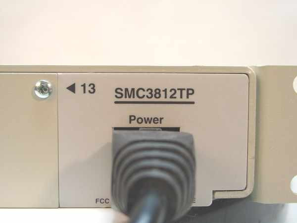 SMC3812TP model number label and power connector close-up on right side panel, with FCC marking visible