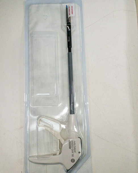 Auto Suture Multifire Endo GIA 30 disposable surgical stapler — device visible inside original clear blister/clamshell packaging, full instrument profile showing shaft and handle