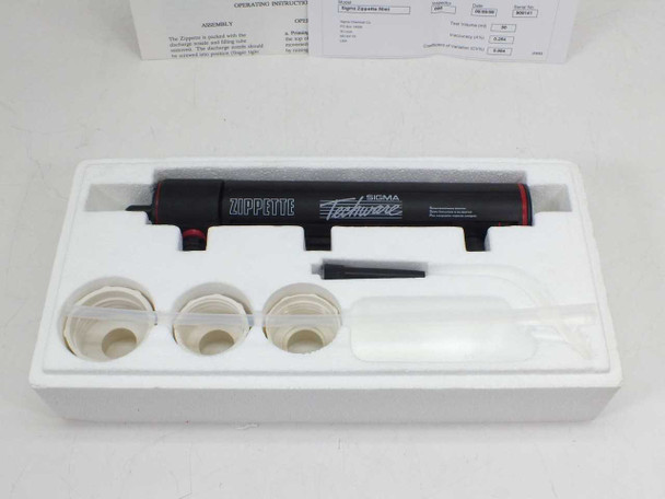 Sigma Zippette D-6544 dispenser body, three white bottle adapters, discharge tube, and small tool laid out in white foam tray with operating instructions in background