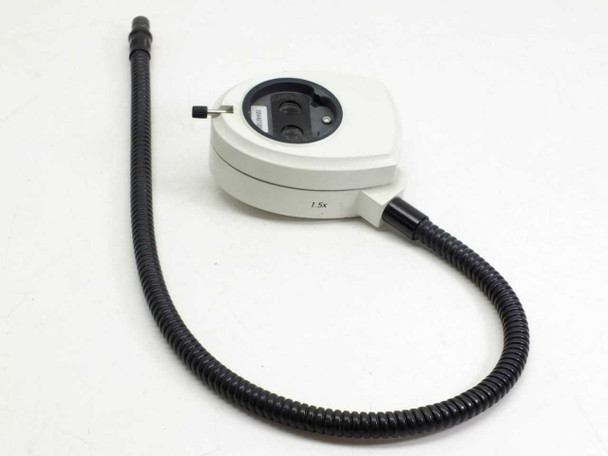 Leica 10446180 coaxial light source – side/top view showing 1.5x magnification marking on body, fiber optic arm, and adjustment pin on housing