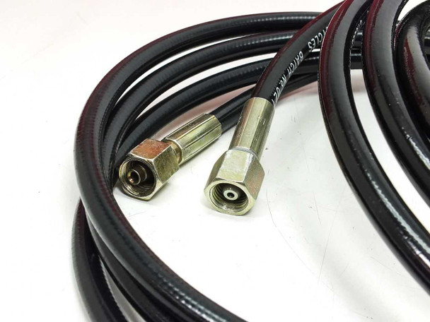 Close-up of Hydac hose ends showing two angled brass fittings on braided high-pressure hydraulic hoses