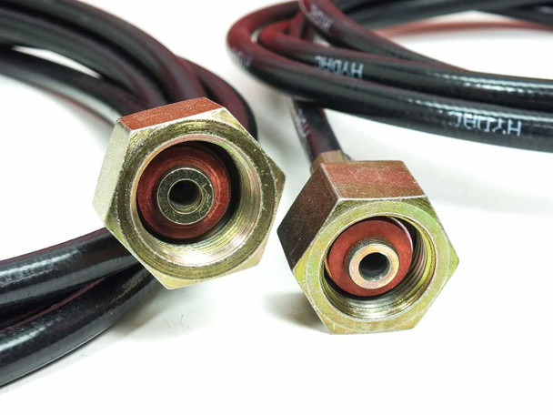 Close-up of two Hydac high-pressure hose end fittings showing swivel brass hex connectors with red seals and HYDAC-branded hose