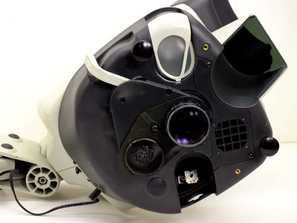 Top cover lifted open showing Mantis internal objective carousel mechanism, empty light socket (missing bulb and cover), ventilation grille, blue indicator LED, and melted plastic area near carousel mount