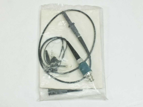 Tektronix P6008 oscilloscope probe with ground lead and accessories visible through clear plastic bag – full probe view