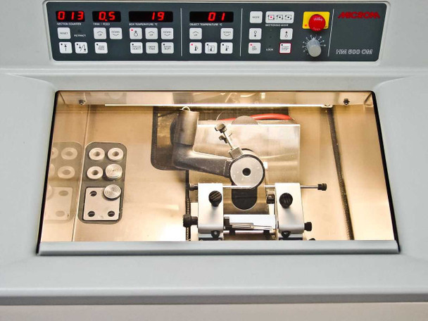 Microm HM500 OM full control panel and open cryostat chamber showing microtome cutting mechanism and specimen chuck holders