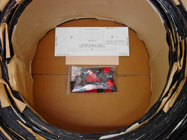 Close-up of Uni-Solar PVL-136 carton interior showing quick-connect connectors bag and installation instruction sheet