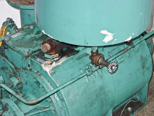 Kinney KDH-130 close-up of top junction between oil separator and pump body – surface rust, chipped and peeling paint, two small fittings and valves visible