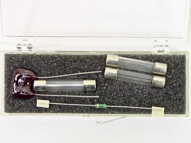 HP 03582 component kit in plastic case with foam insert — red disc capacitor, glass fuse, resistor, and two cylindrical components