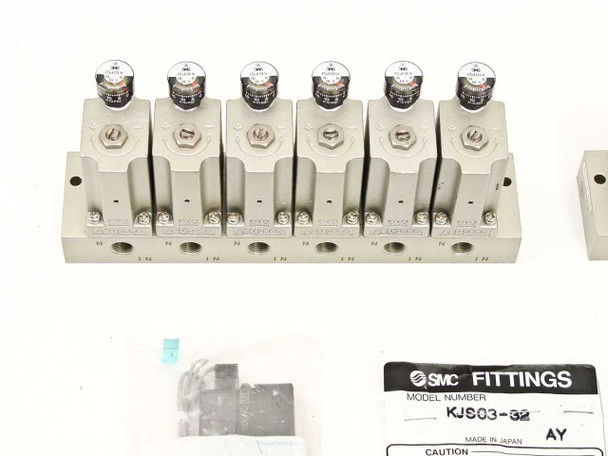 SMC 6-station pneumatic manifold bank with solenoid valves mounted on top, KJS03-32 fittings bag nearby