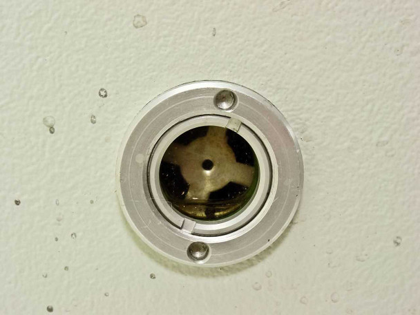 Balzers Pfeiffer DUO 016B exhaust port closeup — circular port with internal tri-vane rotor visible, minor oil residue on housing surface nearby
