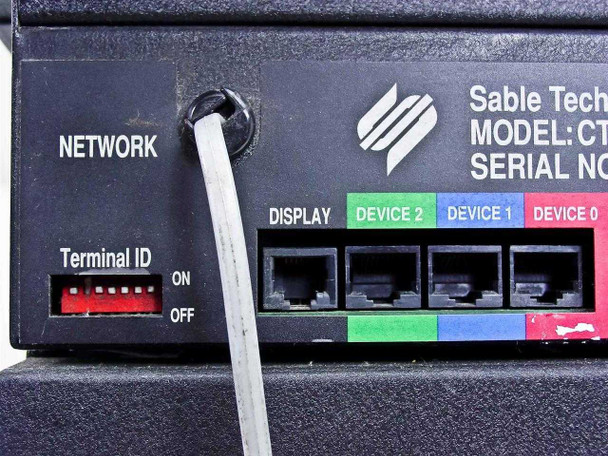 Sable Technologies CT90 MK1.1 rear panel closeup showing NETWORK port, Terminal ID DIP switch, DISPLAY port, and Device 0/1/2 ports with network cable attached