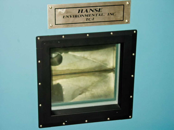Hanse Environmental Inc. TC-1 nameplate and front door observation window close-up showing stainless steel chamber interior