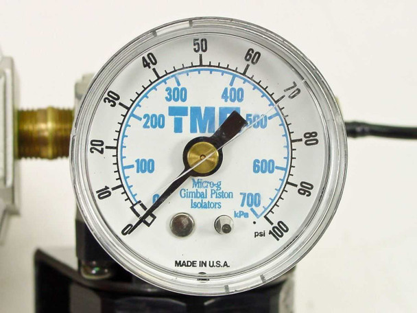 Close-up of TMC Micro-g Gimbal Piston Isolator pressure gauge face — dual scale 0–100 PSI outer and 0–700 kPa inner, Made in U.S.A.