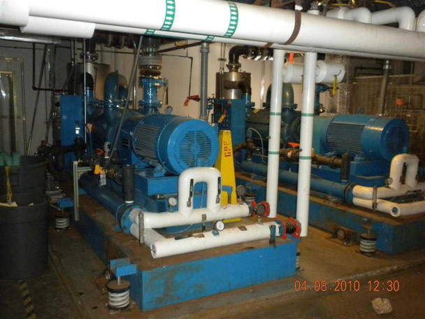 SIHI LPH 85353 vacuum pump skid — wide facility view showing two pump skids side by side with interconnecting white PVC piping, valves, and piping manifold
