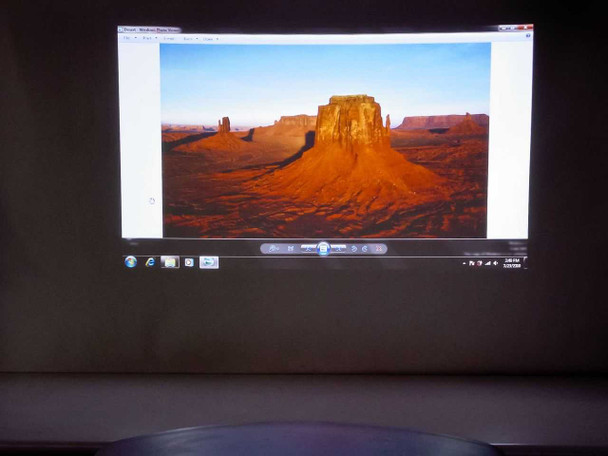 Mitsubishi WD2000 DLP projector displaying widescreen image on wall in darkened room