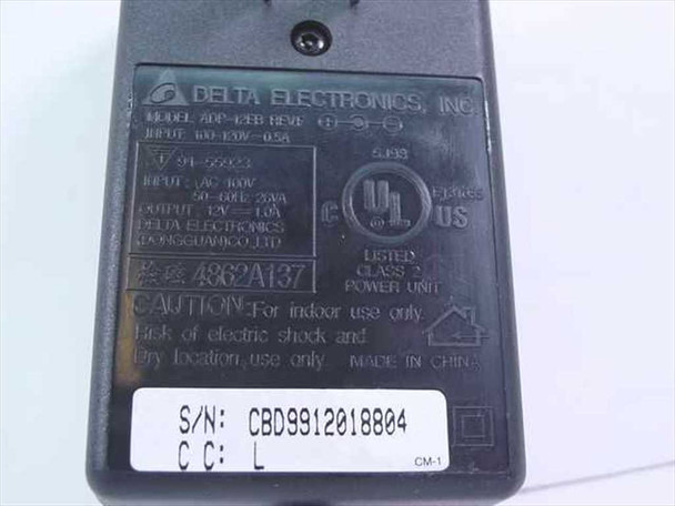 Rear label of Delta Electronics ADP-12EB showing model number, 100-120V 0.5A input, 12V 1A output, UL listing, and serial number sticker