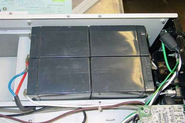 Liebert RT1000-60 UPS interior — closeup of four defective sealed lead-acid batteries in battery tray, top view