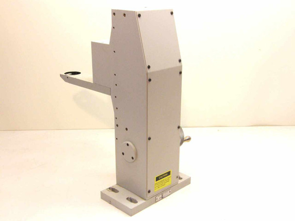 McBain Instruments vertical microscope mount – left-rear view showing flat base with mounting holes, caution label, and side-mounted port on column