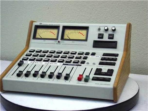 Graham Patton Systems Model 608 Audio Mixer – front 3/4 view showing dual VU meters, 8 faders, push-button channel strips, and wood side panels