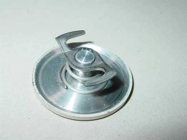 Close-up of small circular metallic fitting or plug component from Nicolet Magnetics NMR magnet assembly