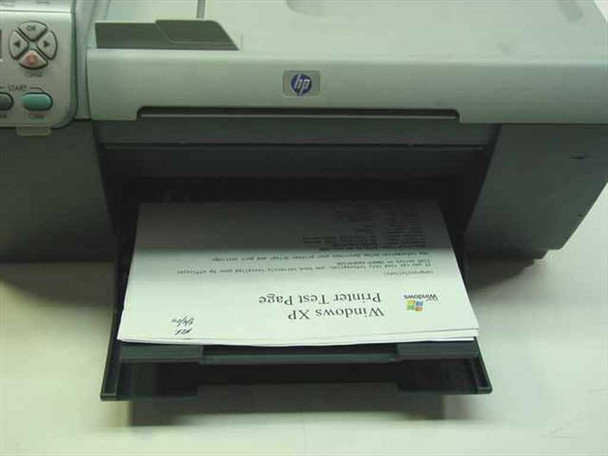 HP OfficeJet 5510 output tray extended with a Windows XP Printer Test Page visible in the tray