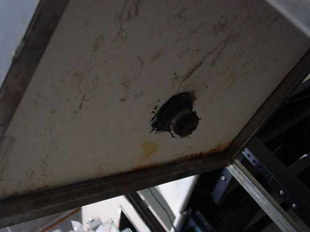 Underside of poly tank lid showing 2-inch NPT bottom fitting with worn thread sealant and surface staining