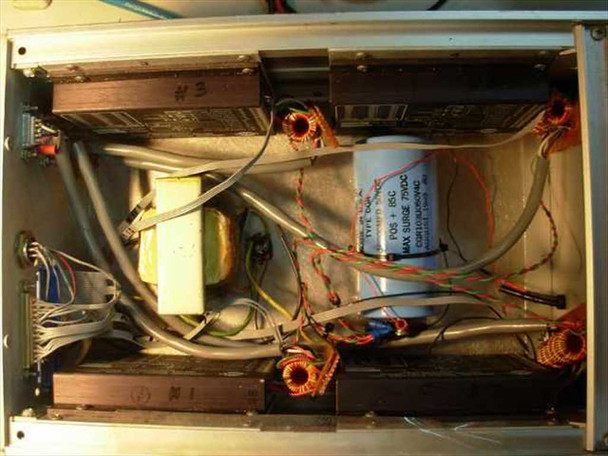 Interior view of MD10A controller box with top cover removed — four OMS MD10A Microstop drive modules, toroidal power transformer, large filter capacitor, and wiring harness visible
