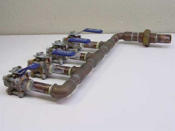 Copper chilled water manifold angled side view — 90° elbow outlet end at right with hex fitting, four Nibco ball valve branches visible from side showing valve body detail and solder joints along main run