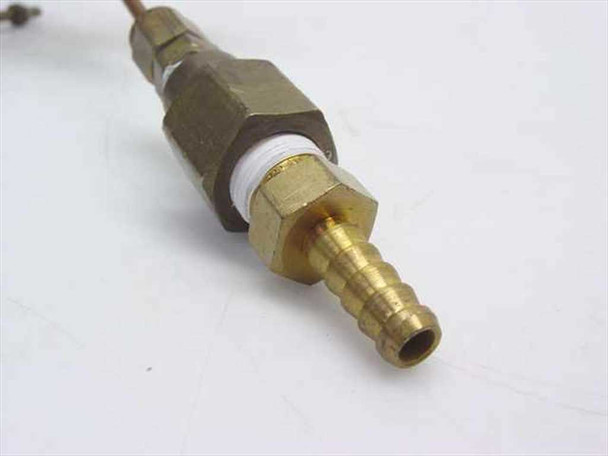 Close-up of brass barb fitting end on Nupro capillary copper tube assembly with white PTFE thread seal visible