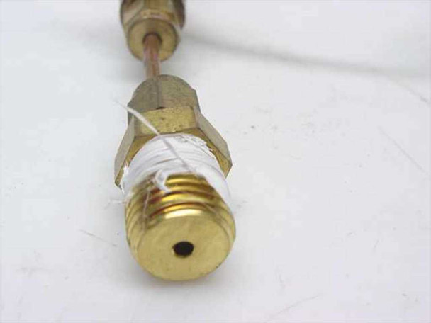 Close-up of brass compression fitting end on Nupro needle valve assembly with threaded port and white thread seal