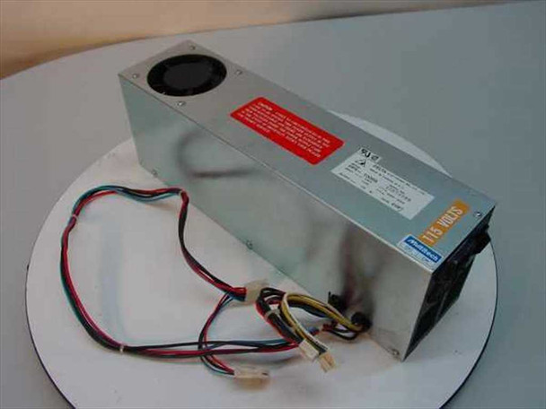 Delta Electronics DPS-100BB 103W AT power supply — three-quarter front view showing metallic silver case, top-mounted fan, red warning label, and AT-style wiring harness with Molex connectors