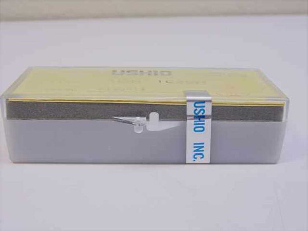 Ushio USH-102DH 100W mercury arc lamp in original clear plastic protective case — side view showing foam cushioning and Ushio Inc label
