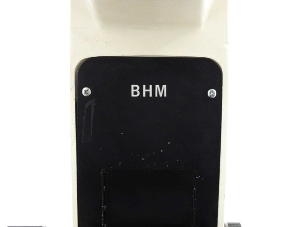 Olympus BHM model designation plate on microscope arm — black panel with white BHM lettering