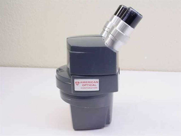 American Optical 571 binocular stereo microscope head – side profile showing American Optical Corporation badge and eyepiece tubes