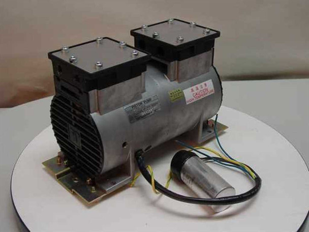 Tosei Engineering PSL-101A dual piston pump front-right view showing twin cylinder heads, motor body, capacitor, and wiring leads on white display stand