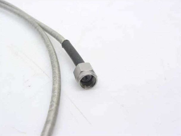 Close-up of second SMA male connector on semi-rigid coaxial cable showing center pin, threaded nut, and braided-to-black-jacket transition